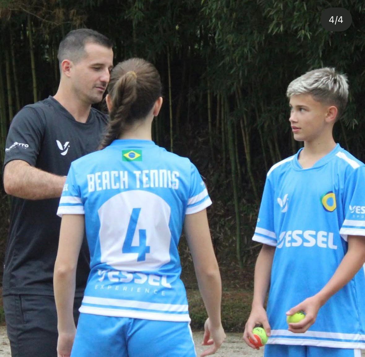 Coach instruindo dupla de atletas de beach tennis
